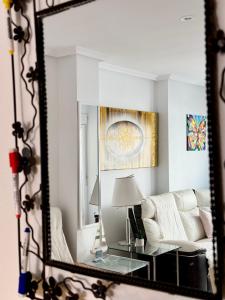 圣波拉San Pedro con ascensor y recogida的镜子反射着客厅的白色沙发