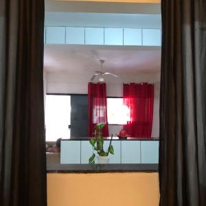 安格拉杜斯雷斯Canto da paz的窗户上带有红色窗帘和植物的厨房