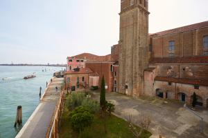 威尼斯Ostello AMDG的水边有钟楼