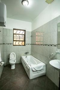 恩德培ST STEVENS SUITES, ENTEBBE的带浴缸、卫生间和盥洗盆的浴室