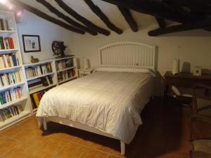 VillatuertaCasa Rural 643km的卧室配有白色的床和书架
