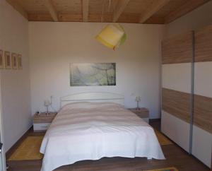 AgraCasa Torretta的卧室配有白色的床和墙上的绘画作品