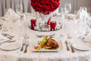 拉瓦尔拉瓦尔蒙特利尔假日酒店的一张桌子,上面有一盘食物和一瓶玫瑰花