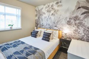 布里德灵顿Cosy Coastal Apartment 1的卧室配有一张床,墙上挂着壁画