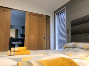 布里奇诺斯Shropshire Lodges - Romantic Luxury Hot Tub Breaks的一间卧室配有一张带黄色枕头的大床