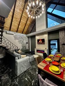 盖贝莱Qafqaz Modern Chalet的客厅配有餐桌和壁炉