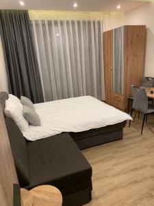 科帕奥尼克Residence Hill A83的一间卧室配有一张带白色床单的床和一张书桌。