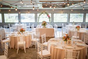 密尔沃基密尔沃基滨河假日酒店的婚礼招待会,配有白色的桌椅和鲜花