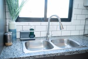 圣地亚哥洛斯卡巴Happy to welcome you too modern的厨房里的一个不锈钢水槽,窗户