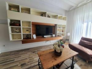 塔拉戈纳EF7 Beds & Family的客厅配有电视、桌子和沙发