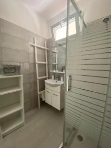 马鲁焦Pinulà的一间带玻璃淋浴和水槽的浴室