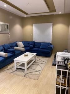麦地那Alfatih apartments شقة الفتح的客厅配有蓝色的沙发和白色的咖啡桌。