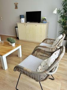 霍勒姆Kaap 10的客厅里的藤椅,配有电视