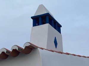 莫托拉Casa Vó Briata的一座白色的建筑,上面有蓝色的塔