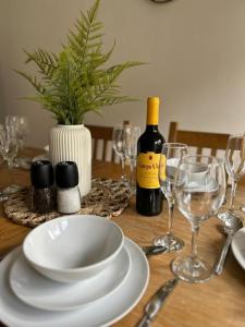 希钦Stylish 3 Bed House Hitchin的一张带白板的桌子和一瓶葡萄酒