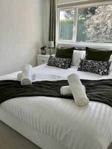 希钦Stylish 3 Bed House Hitchin的一张带枕头和窗户的大型白色床