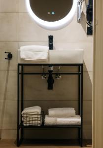 法尔肯堡Hotel Blink的浴室配有盥洗盆、镜子和毛巾