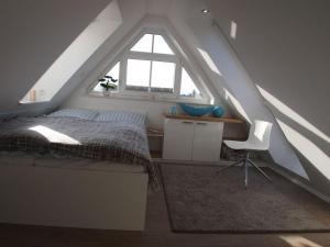 万根沃格Boothäuser Living_art Wangerooge的一间卧室配有一张床、一张书桌和一个窗户。