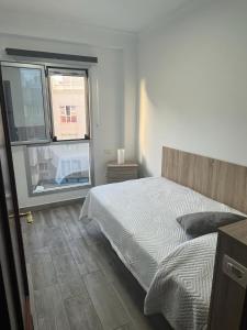 加尔达尔Acogedor apartamento con piscina yedae的一间卧室设有一张床和一个大窗户