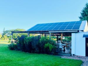 普利登堡湾Bella Manga Country Escape的花园中设有太阳能电池组的凉亭