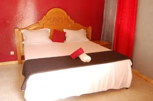 萨利尼亚拉尔Melia's hotel的卧室配有一张白色大床和红色墙壁