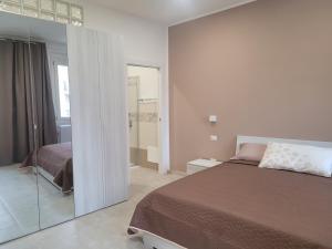 萨萨里Domo Azuni的一间卧室设有一张床和玻璃墙