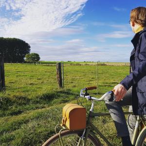 迪尔森-斯托科姆Guesthouse De Wissen的一位妇女在田野骑着自行车