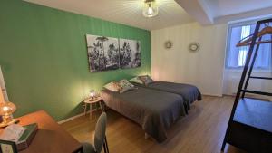 Chanos-CursonLa Ferme des Denis的绿色卧室配有床和桌子