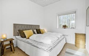 维斯特索马肯Cozy Home In Aakirkeby With Kitchen的白色卧室配有一张带黄色枕头的大床