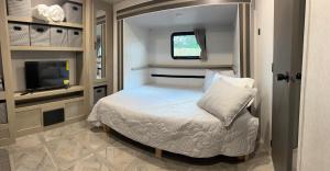 霍姆斯泰德Homestead RV的一间带床和电视的小卧室