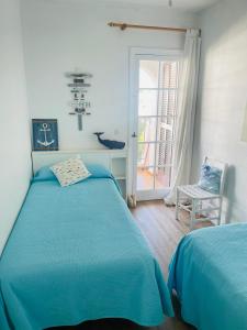 卡拉恩波特Precioso apartamento piscinas Cala en Porter的一间卧室配有蓝色的床和椅子