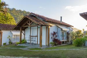 伊皮亚巴斯Pousada das Bromélias的白色的小房子,设有木屋顶
