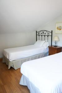 布埃乌Casa Videira - Hotel rural cerca del mar的配有白色床单的客房内的两张床
