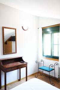 布埃乌Casa Videira - Hotel rural cerca del mar的一个带椅子的房间,里面装有镜子和钢琴