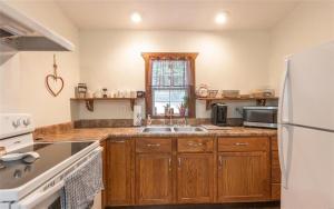 RangelyDragonfly Meadows Guesthouse的厨房配有木制橱柜和白色冰箱。
