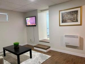 坎贝尔顿Ting’s Place - Luxury suite的客厅配有桌子,墙上配有电视