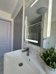 南埃福列Plexus Boutique的白色的浴室设有水槽和镜子