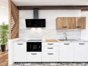 洛斯·亚诺斯·德·阿里丹La Zarza by Huskalia的白色的厨房设有水槽和电视。