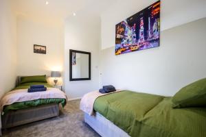 巴特利Home in West Yorkshire, Close to Leeds City Center, Sleeps 3!的一间卧室配有两张床和镜子