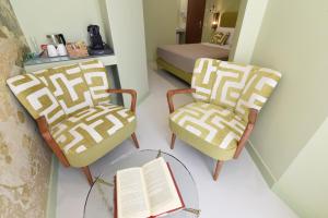 索伦托Sorrento Rooms Deluxe的一间设有两把椅子和一张桌子及书籍的房间