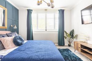 Streatham HillGorgeous House in Sidcup的一间卧室设有蓝色的床和窗户。