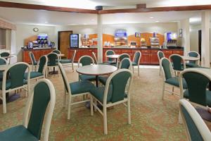 科罗拉多斯普林斯Holiday Inn Express & Suites Colorado Springs-Airport, an IHG Hotel的一间设有桌椅的等候室