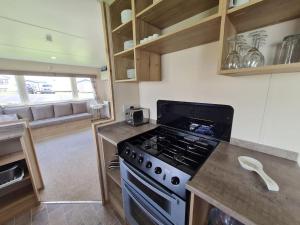 埃克斯茅斯3 Bedroom Deluxe Caravan at Haven Devon Cliffs的厨房配有炉灶和台面