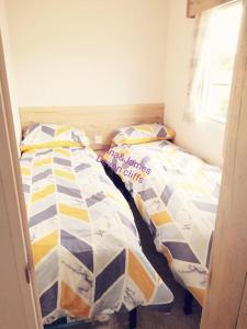 埃克斯茅斯3 Bedroom Deluxe Caravan at Haven Devon Cliffs的双床间设有2张单人床。