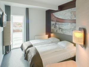 瓦埃勒B&B HOTEL Vejle的酒店客房设有一张床和一个大窗户