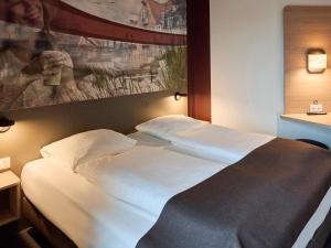 瓦埃勒B&B HOTEL Vejle的一张大白色的床,位于酒店客房内