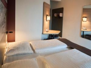 瓦埃勒B&B HOTEL Vejle的酒店客房设有两张床和盥洗盆
