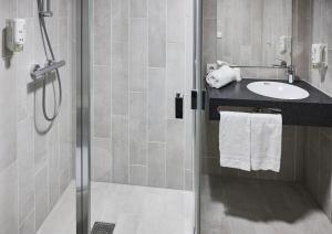 瓦埃勒B&B HOTEL Vejle的带淋浴、盥洗盆和淋浴的浴室
