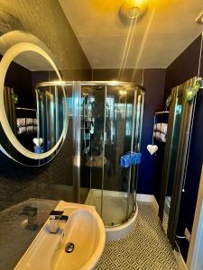 洛哈尔什教区凯尔高地The Lodge Dunrowan的带淋浴、盥洗盆和镜子的浴室