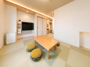 Tokai东海城市酒店的客厅配有木桌和2张凳子